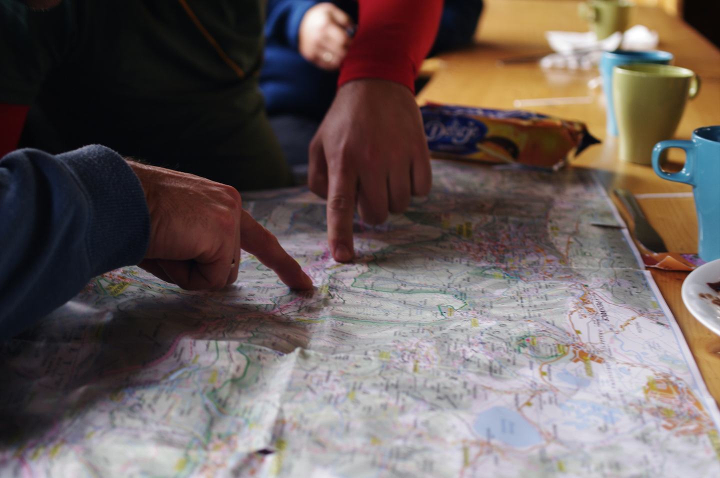 Multiple people standing around a map going over a plan at a table