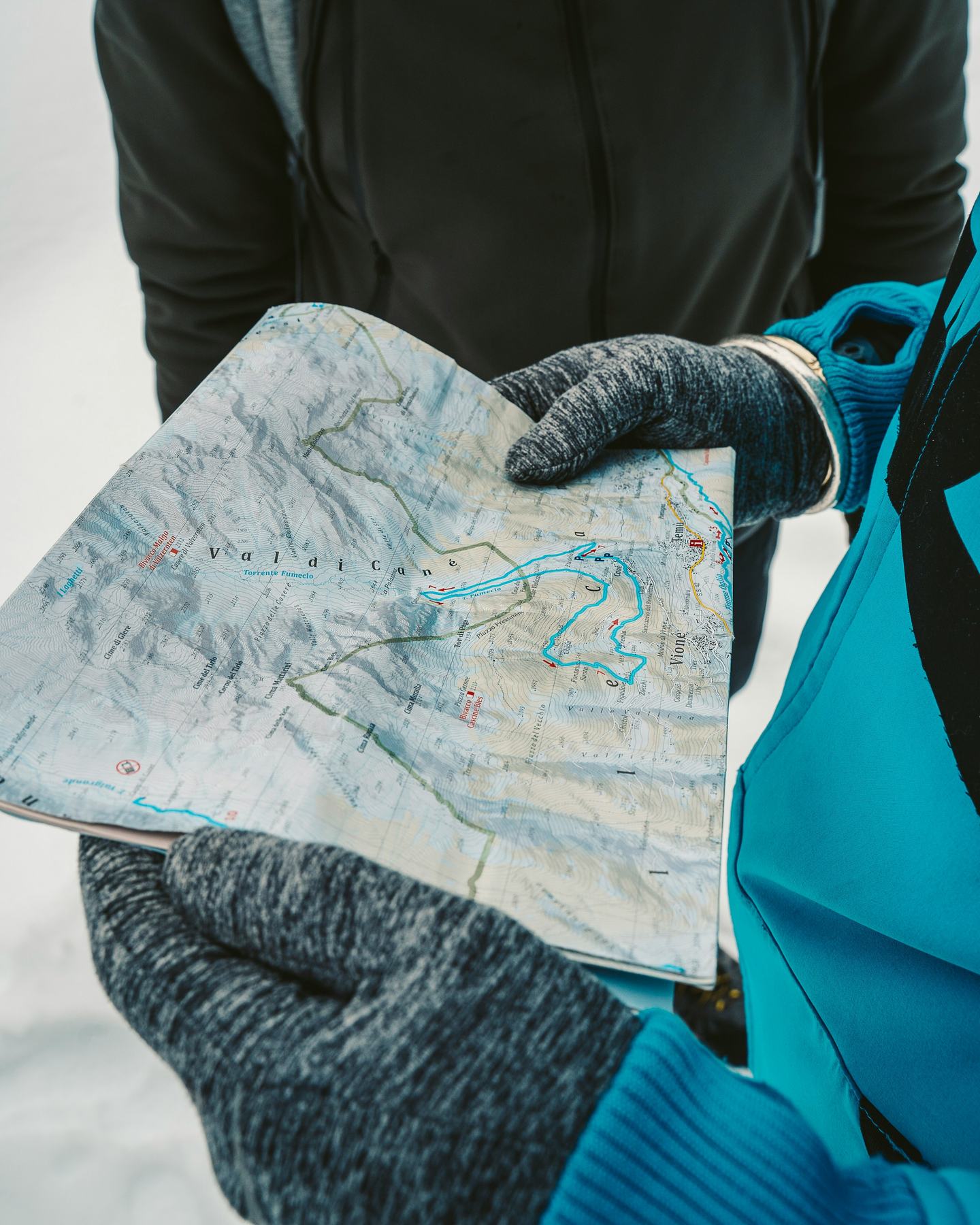 Two people in the snow reviewing a map