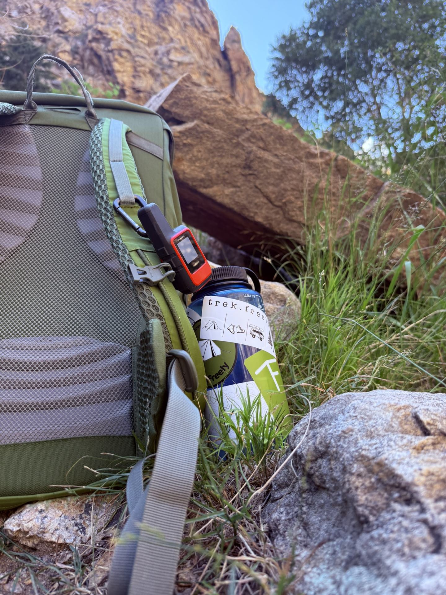 A Garmin inReach Mini 2, a ZOLEO, and a SPOT Gen4 laid out side by side.