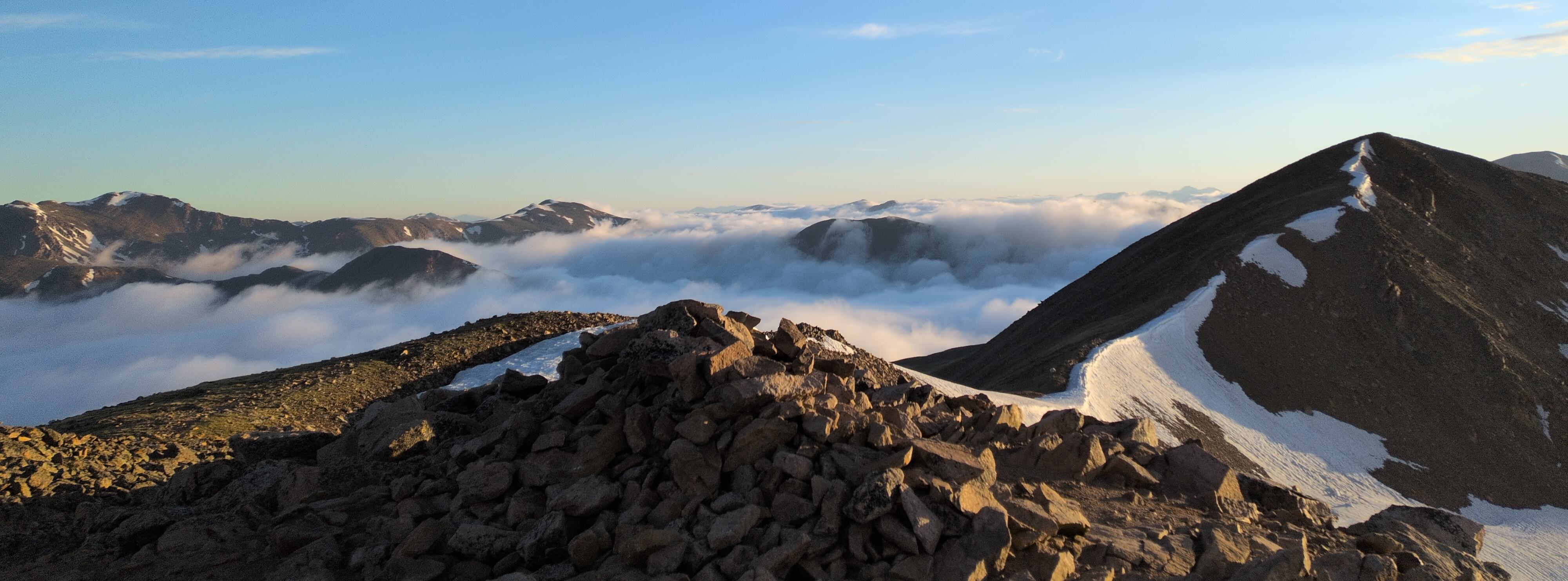 A scenic image of low cloud cover over a early morning sunrise in the mountains